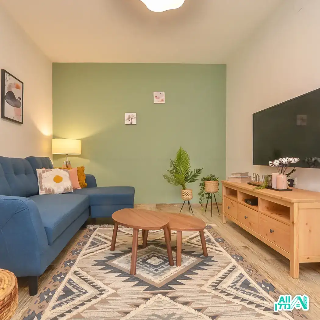 סלון עם קיר כוח ירקרק וספה כחולה