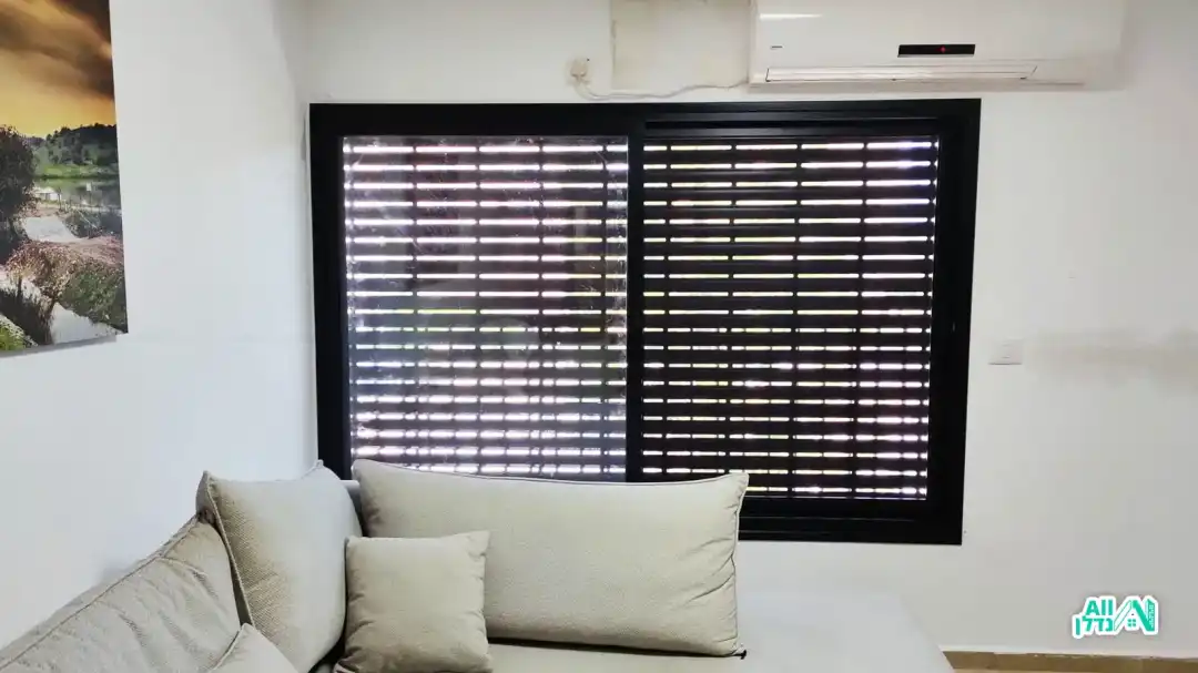 חלון במסגרת שחורה ותריס חשמלי