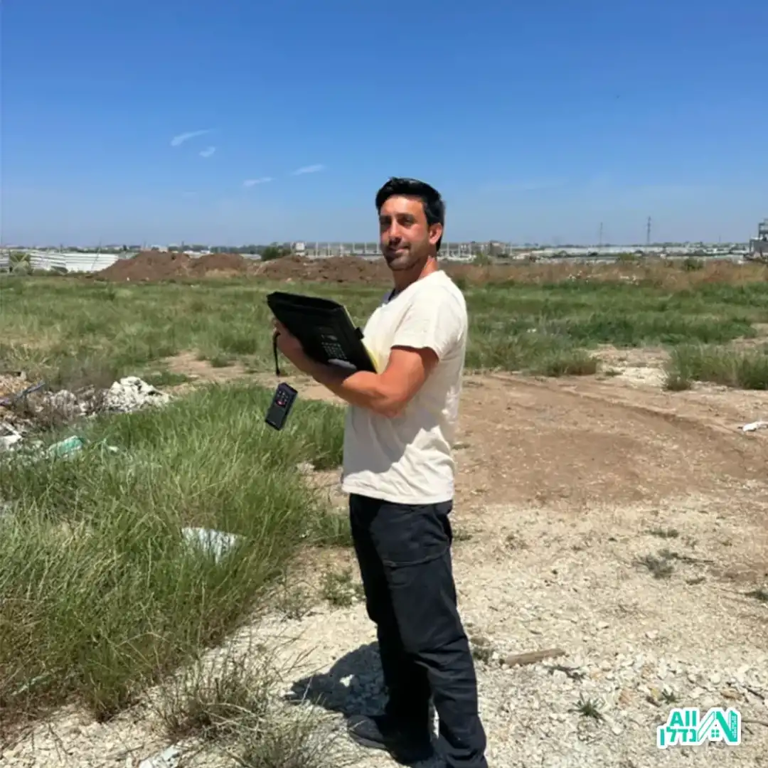 משה השמאי בזמן מדידה בשטח פתוח