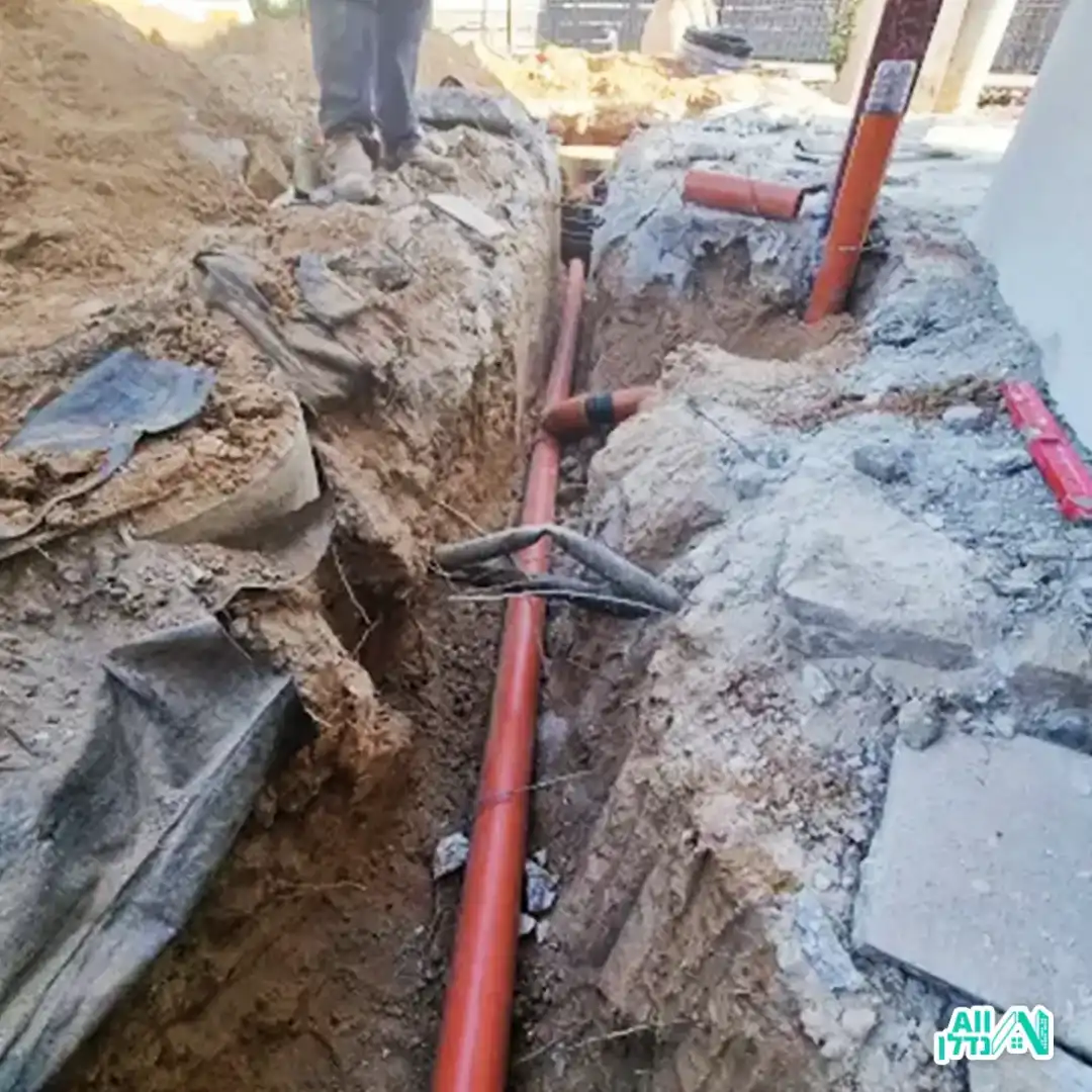 בעל מקצוע קודח בקיר להתקנת קווי אינסטלציה