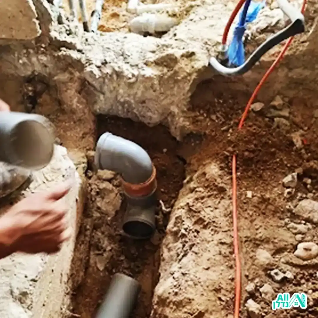 בעל מקצוע קודח בקיר להתקנת קווי אינסטלציה