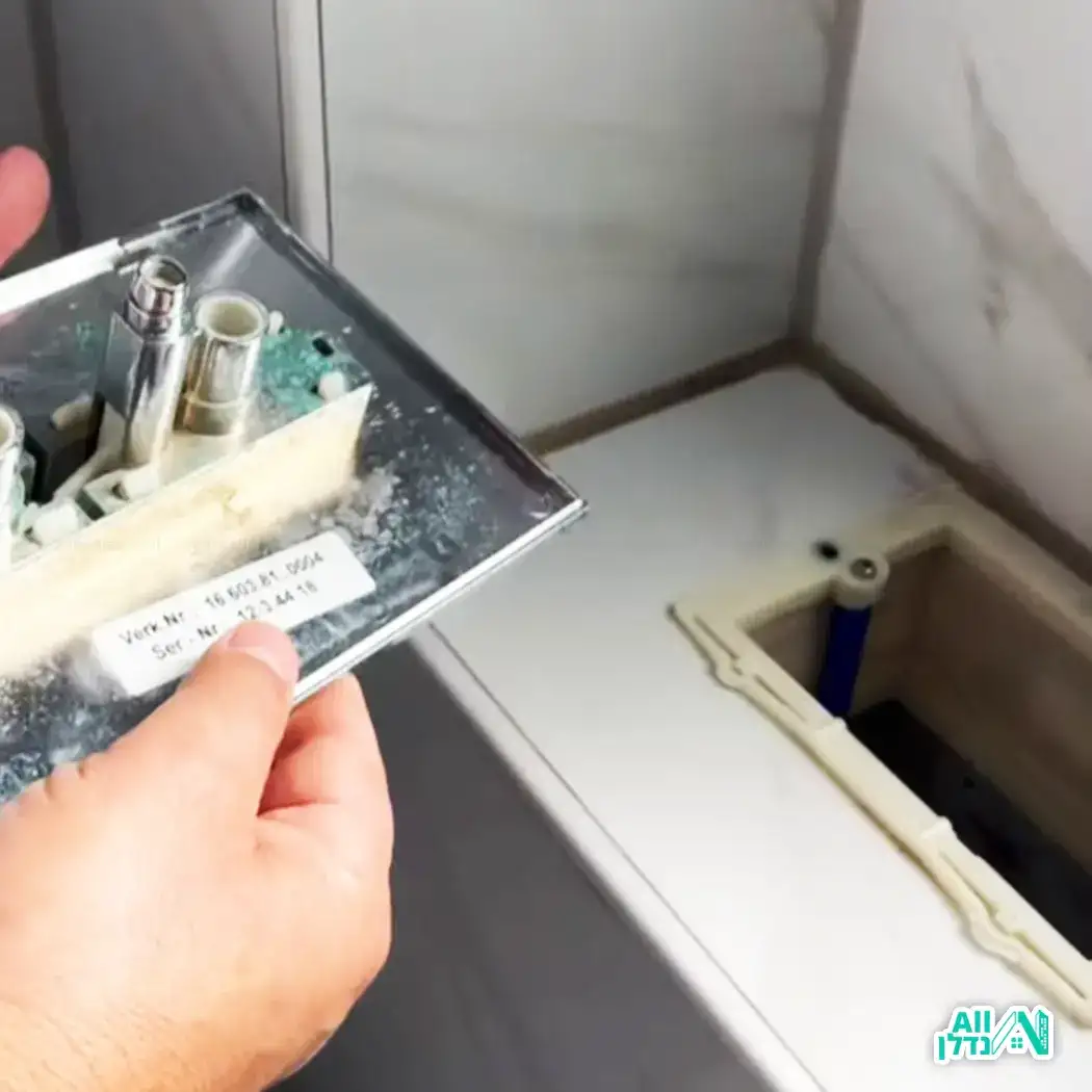 אינסטלטור מתקן את האסלה והזרימת מים