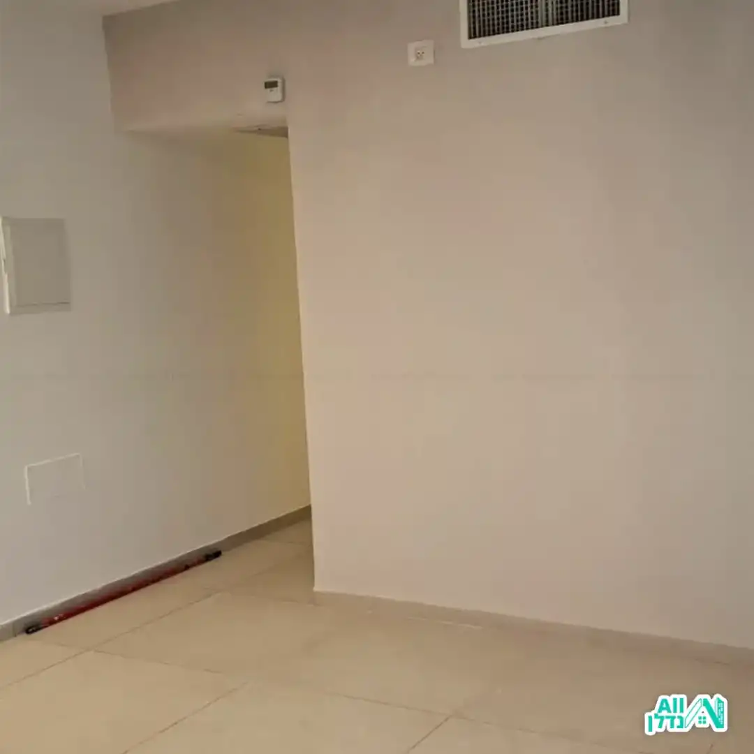 קיר צבוע לידו דלי צבע ומקל ששימש לצביעה