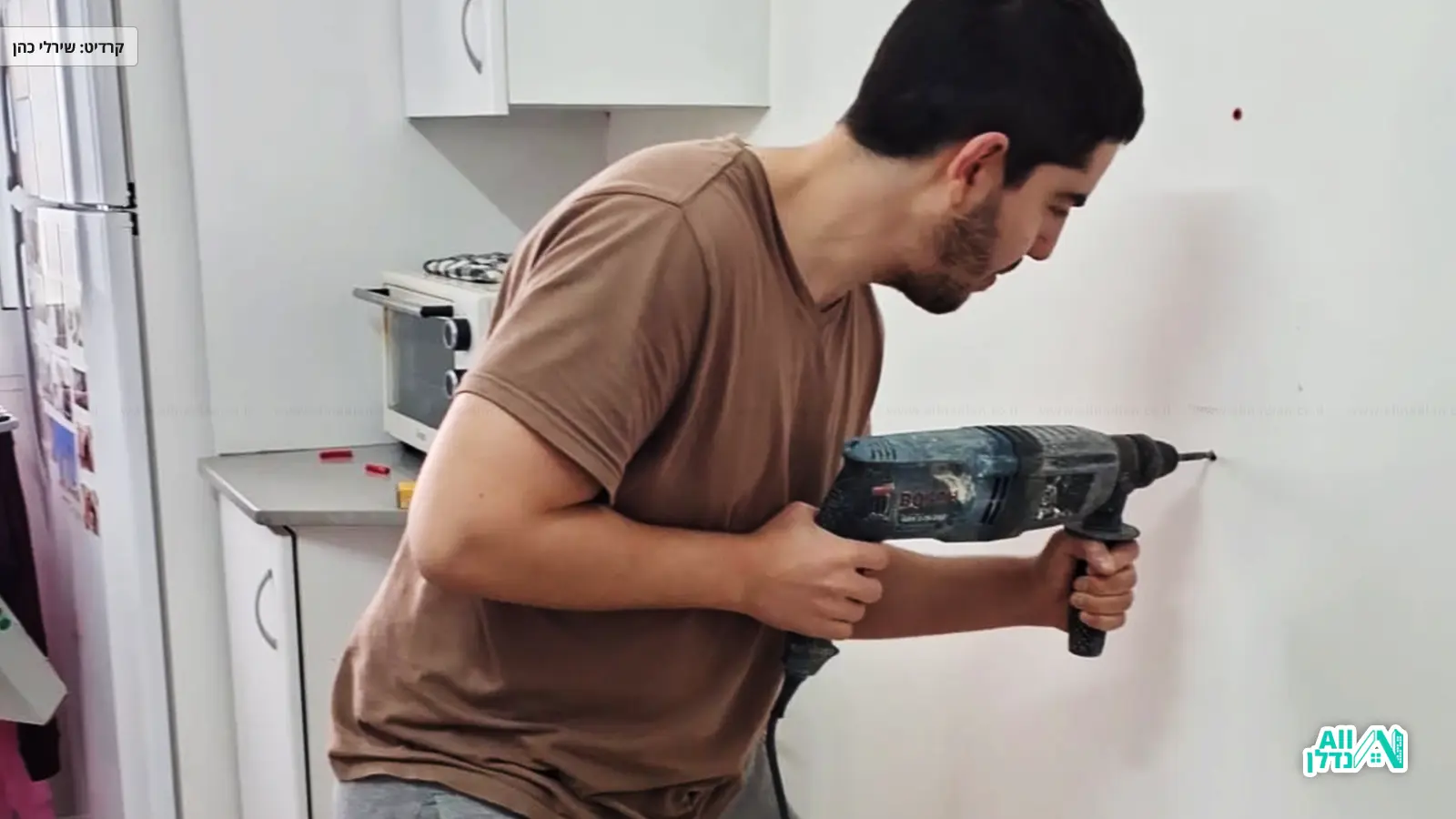 הנדימן קודח חור בקיר עם מקדחה
